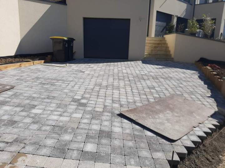 Pose de pavés 16x16 gris dans une cour 